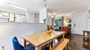 Una sala de estar moderna con una mesa de comedor de madera, sillas azules y un sofá.