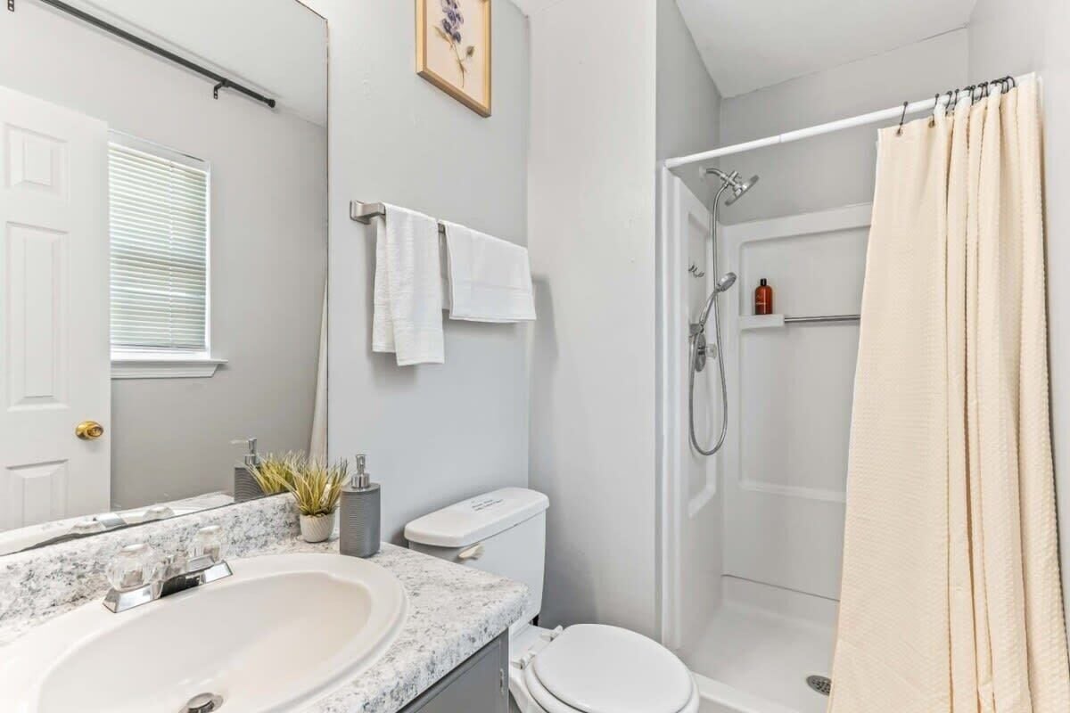 A bathroom with a sink, toilet, and shower.