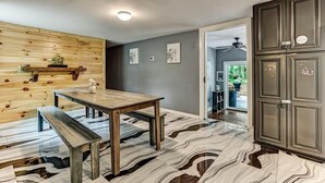 Eine moderne Küche mit einer Holz-Akzentwand, einem Marmorboden und einer eingebauten Bank.