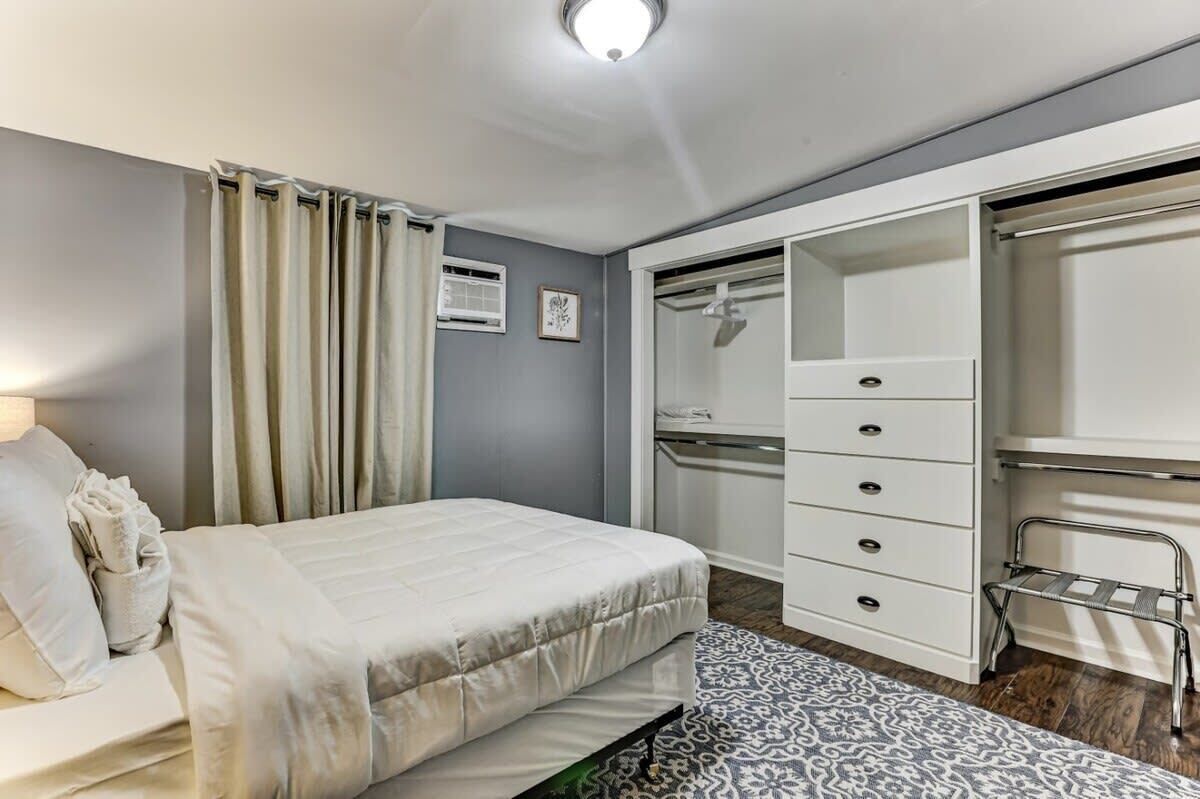 A bedroom with a bed, a wardrobe, and a walk-in closet.