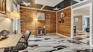 Ein Konferenzraum mit Holzwand, Marmorboden, einem Schreibtisch mit Stühlen, einem Globus und einem sternförmigen Deckenmuster.