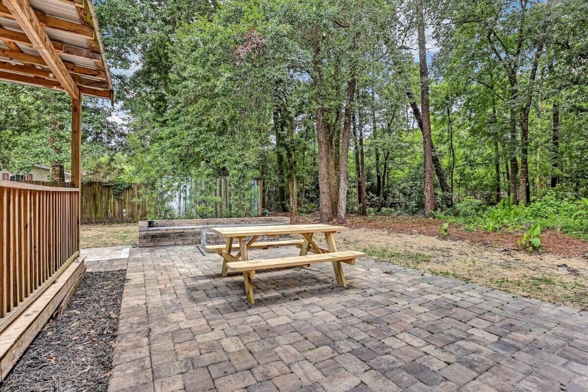 A wooden deck with picnic tables and a pergola.