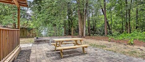 A wooden deck with picnic tables and a pergola.