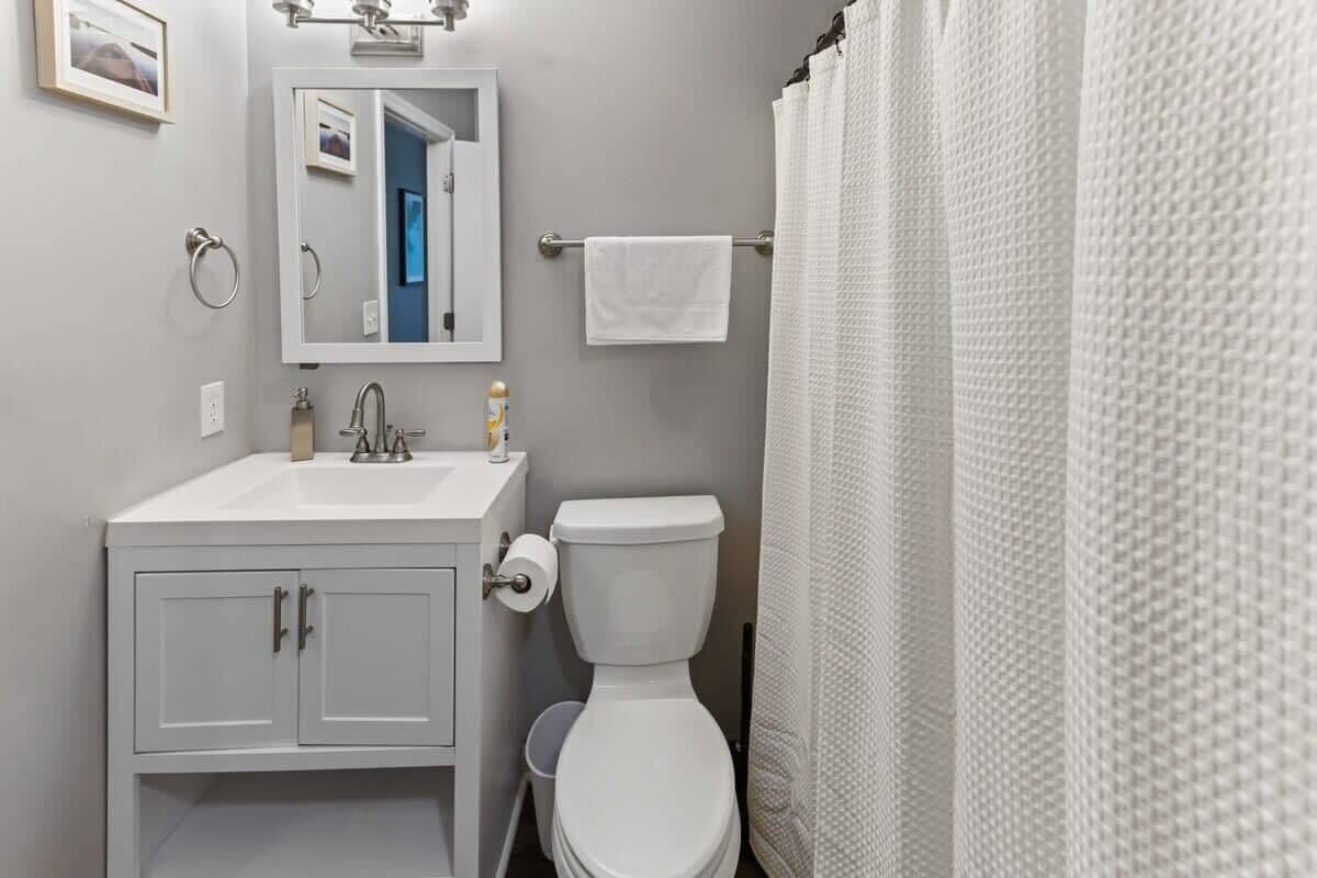 Ein Badezimmer mit Waschbecken, Spiegel und Toilette.