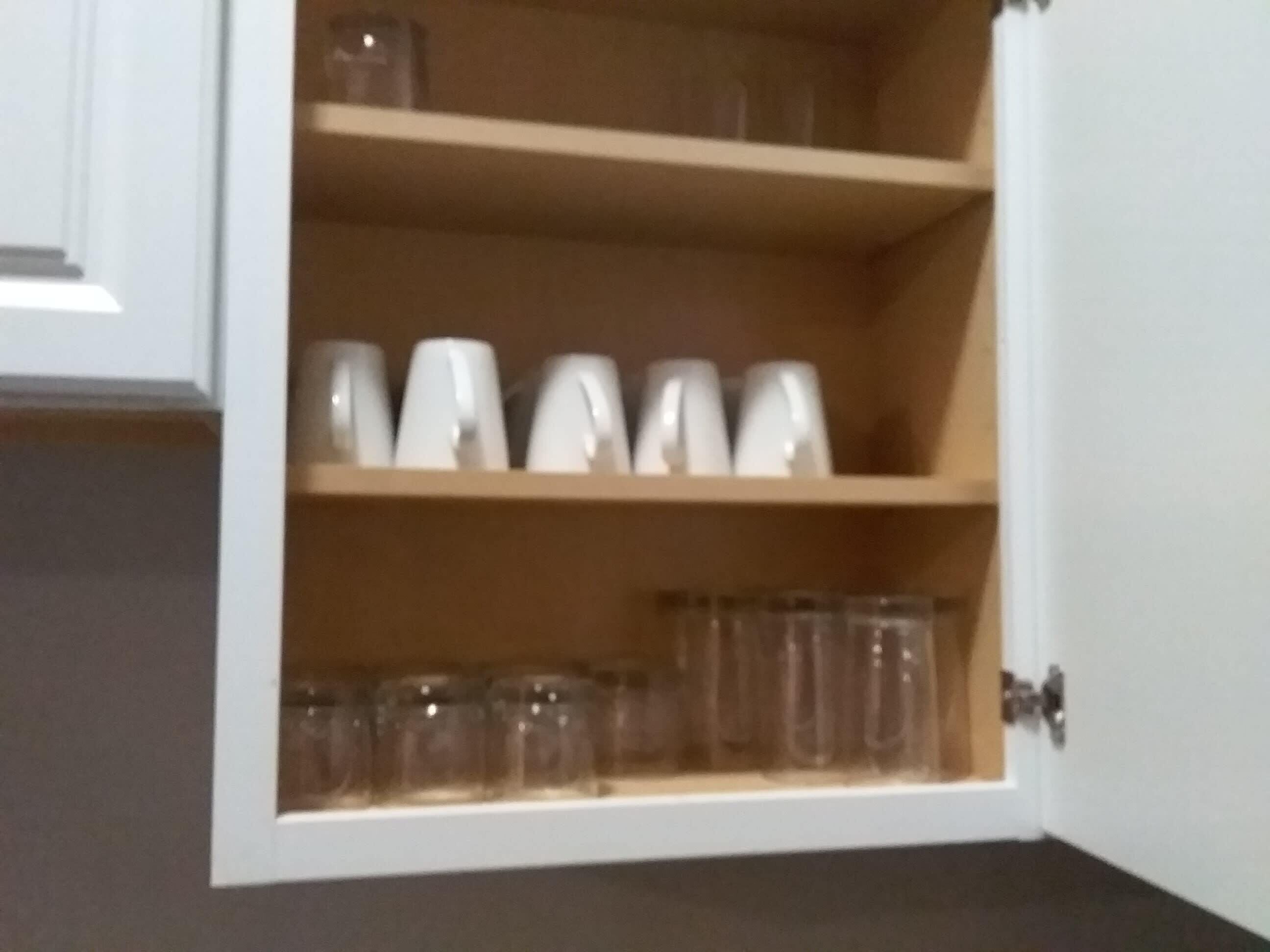 A cabinet with shelves containing various glassware.