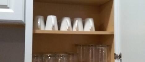 A cabinet with shelves containing various glassware.