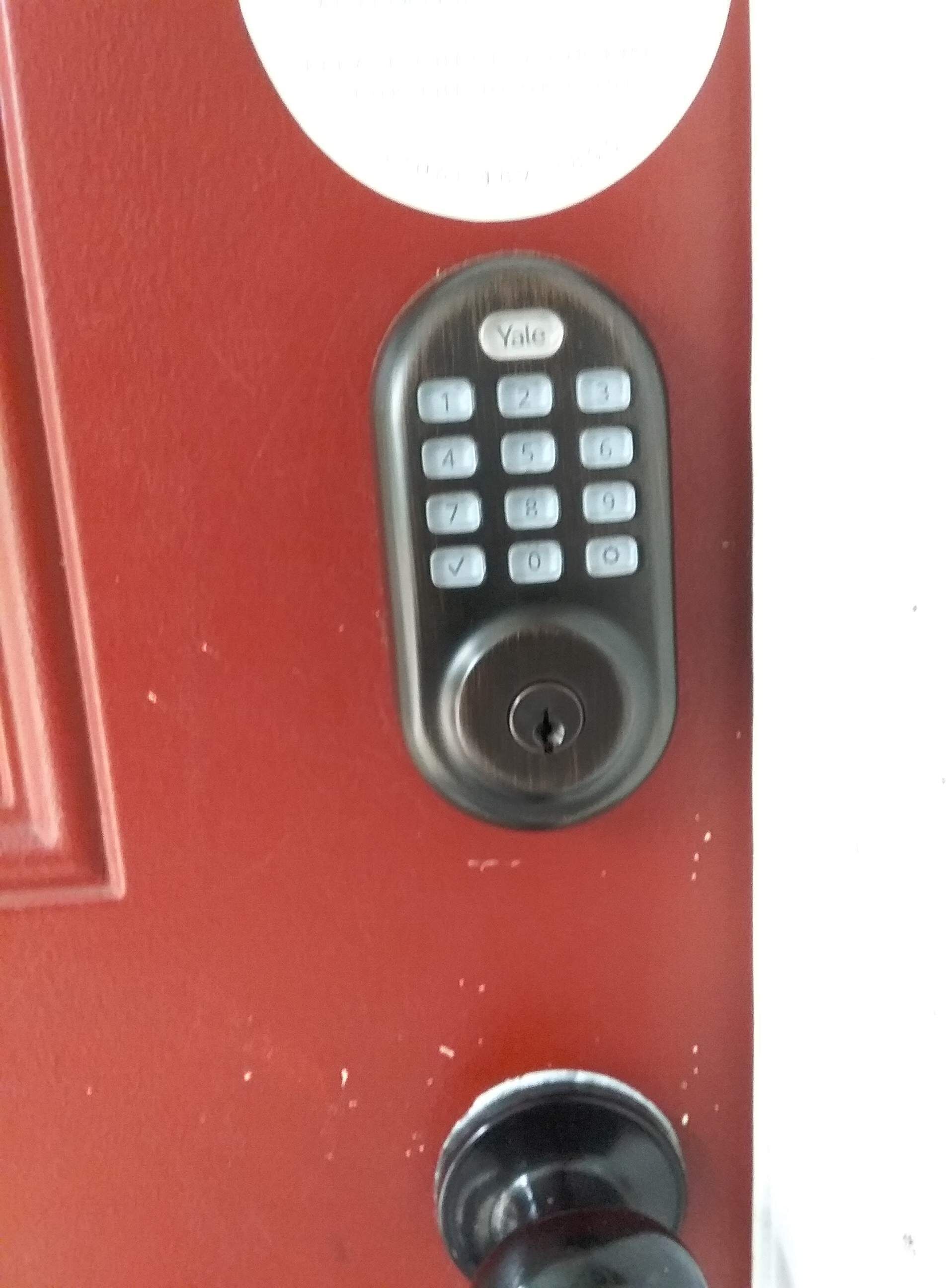 Una serratura elettronica Yale su una porta rossa.