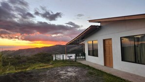 A modern house with a balcony overlooking a mountainous landscape at sunset. - Magic Place Monteverde  (Monteverde)