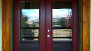 A red door with a view of a mountainous landscape through a window. - Sequoia Luxury Ranch House, View, Pool, horses, 30 min to Park, in Foothills (Exeter)