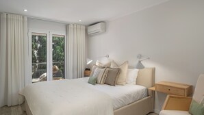 A bedroom with a large bed, a nightstand, a chair, and a window with curtains. - Promenade II – Comfort and Elegance in Funchal (Funchal)