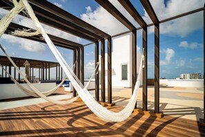 A hammock on a wooden deck with a view of the city skyline. - Barcelona Condos Cancun (Cancún)