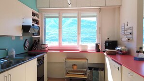 Una cocina compacta con ventana, un lavamanos, una estufa y un horno pequeño.