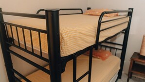 A bunk bed with a checkered yellow and white mattress, a black metal frame, and a small wooden nightstand beside it. - 2 bedroom house with swimming pool in Ixtapa (San José Ixtapa)