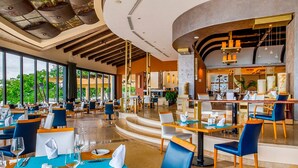 A spacious restaurant with high ceilings, large windows, and a modern interior design.