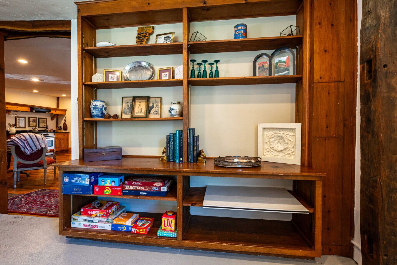 Une bibliothèque en bois contenant divers objets, notamment des livres, des photos encadrées et des objets décoratifs.