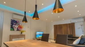 A modern living room with a wooden dining table, black chairs, and pendant lighting. - Suncity Luxury 2 bedroom apartment | Rooftop pool & Gym (Accra)