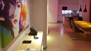A modern kitchen with a central island, pendant lighting, and a dining area with chairs and a table. - Suncity Luxury 2 bedroom apartment | Rooftop pool & Gym (Accra)