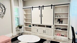 A room with a white wardrobe, shelves with toys, a small table, and a potted plant. - 
Charming 2-bedroom house in wonderful Austin with WiFi, AC (Austin)