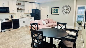 A modern kitchen with white cabinets, a black refrigerator, and a dining area with a round table and black chairs. - 
Charming 2-bedroom house in wonderful Austin with WiFi, AC (Austin)