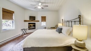 A bedroom with a bed, a ceiling fan, a fireplace, and a TV. - Private Rm 1, Handicap Accessible, 10 quiet acres (Swanton)