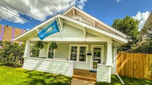 A single-story house with a front porch, a mailbox, and a number sign indicating the address.