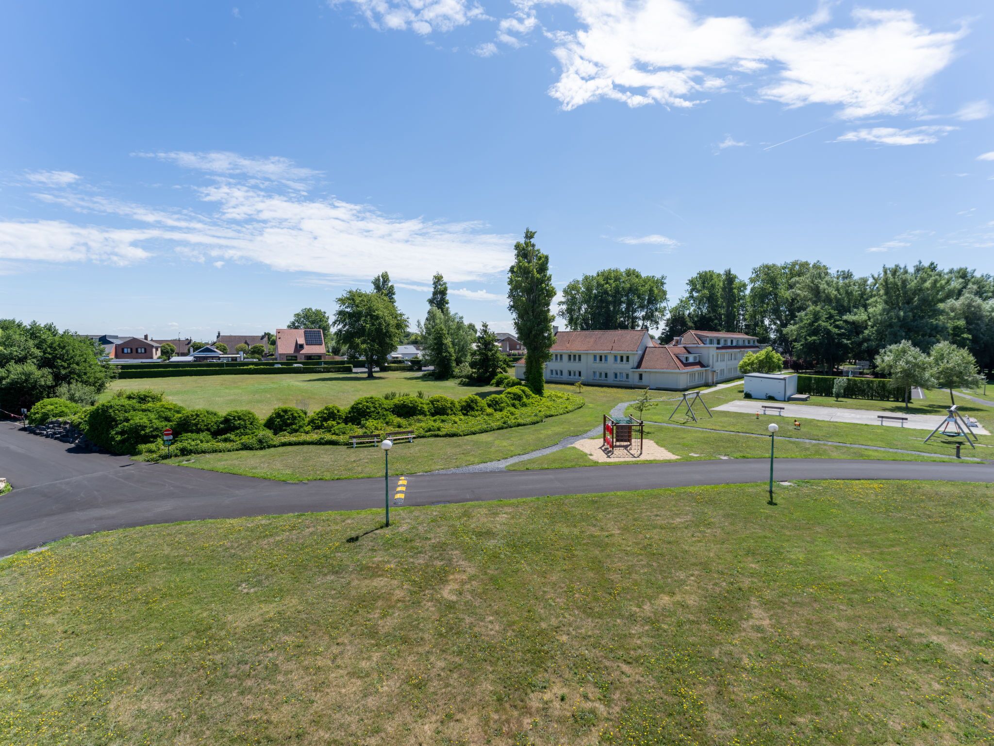 A residential area with houses, a playground, and a road.