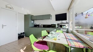 Una cocina moderna con comedor, televisor y ventana con vistas.