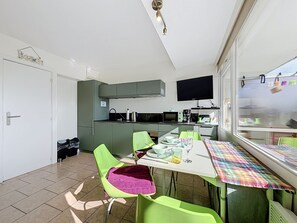 Une cuisine moderne avec un coin repas, un téléviseur et une fenêtre donnant sur un beau paysage.