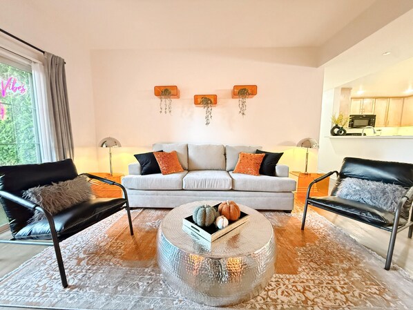 A modern living room with a grey sofa, two black leather armchairs, a round coffee table, and a patterned rug. - Charming 3BR with WiFi, AC and Parking in Marvelous Los Angeles (Los Angeles)