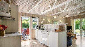 A modern kitchen with white cabinetry, a central island, and pendant lighting. - Pet friendly home in Tarm with WiFi (Tarm)