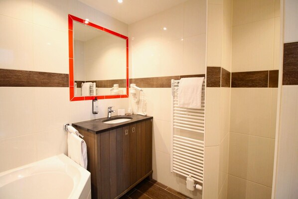 A bathroom with a sink, mirror, and towel rack.