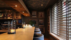 A bar area with a long counter, stools, and a variety of bottles and glasses. - Best Western Beach Hotel Bergen Aan Zee (Bergen aan Zee)