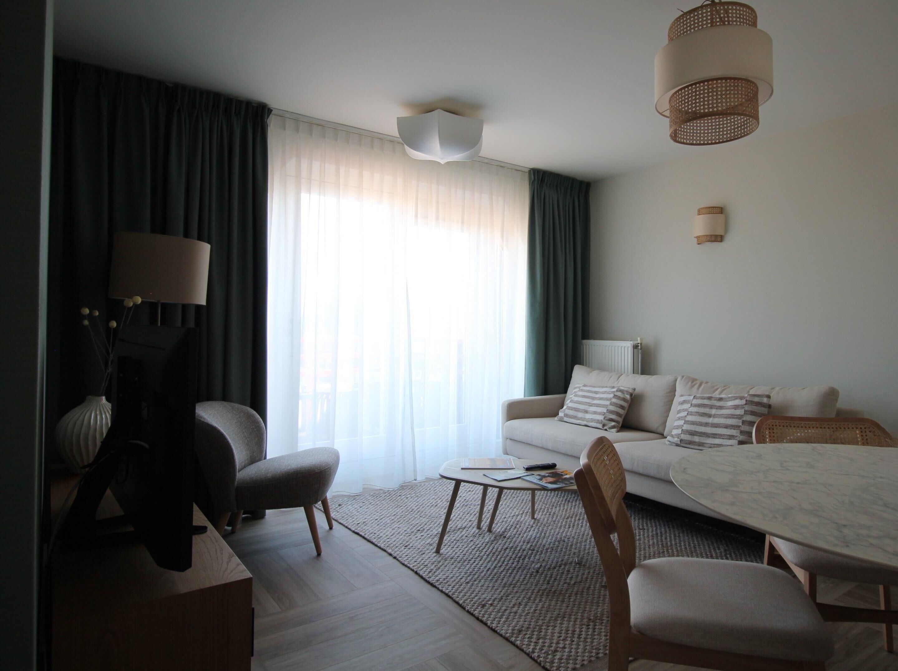 A modern living room with a sofa, chairs, a coffee table, and a dining table.