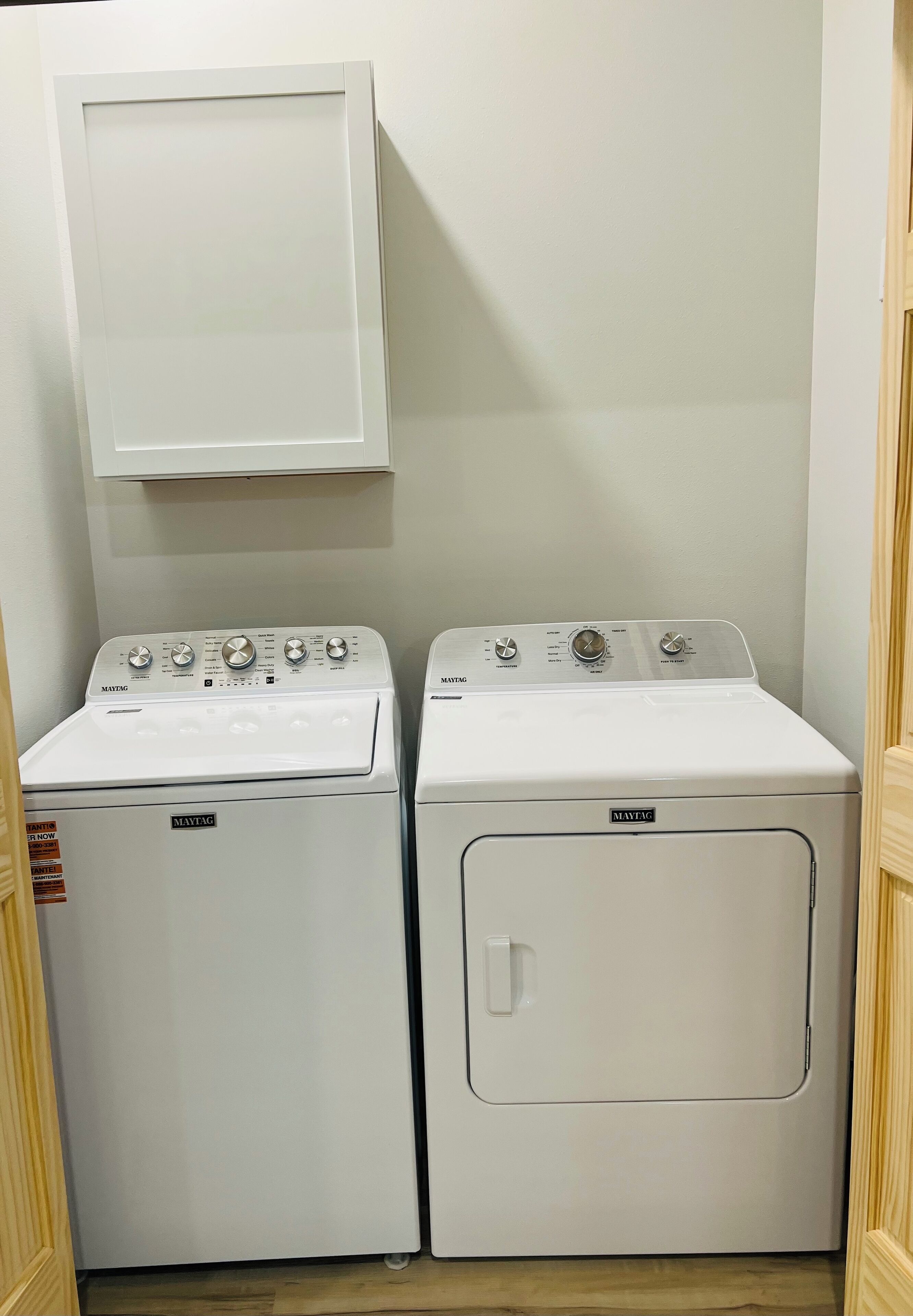 A laundry room with two Maytag washing machines and a dryer.