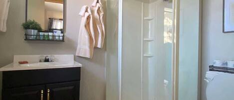 Een douche, handdoeken, zeep, toiletpapier