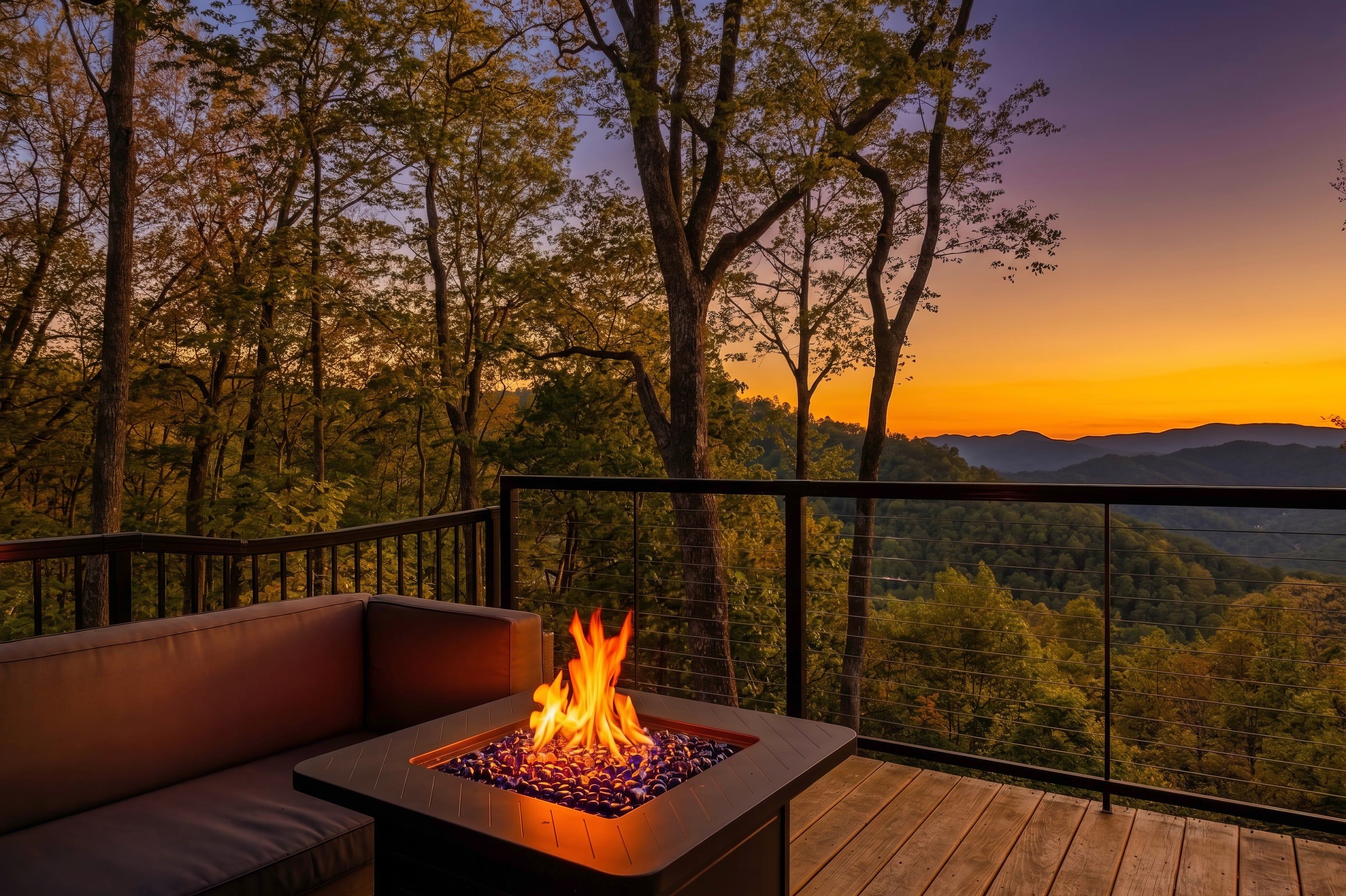A fire pit on a deck with a view of a forest and mountains.