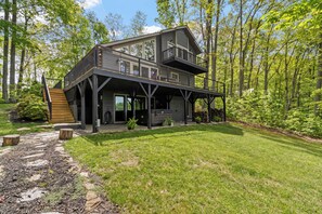 Ein zweistöckiges Haus mit Balkon, umgeben von einem Wald.