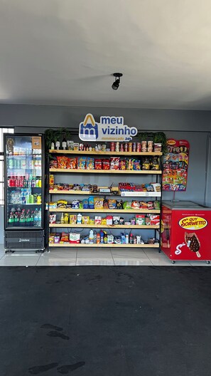 Een gemakswinkel met een koelvak, schappen vol lekkernijen en een display met ijs van het merk.
