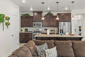 A modern kitchen with dark wood cabinets, stainless steel appliances, and a central island.