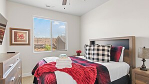 A bedroom with a bed, a dresser, a nightstand, a lamp, a window with blinds, and a framed picture on the wall. - Above Parr - Pet Friendly New Listing (Washington)