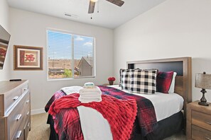 A bedroom with a bed, a dresser, a nightstand, a lamp, a window with blinds, and a framed picture on the wall. - Above Parr - Pet Friendly New Listing (Washington)