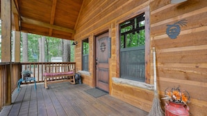 A wooden cabin with a porch, a bench, a door with a 'Welcome' sign, and a red fire extinguisher. - Cozy Cabin 3 miles to WPG Slps 4, ATV friendly (Mena)