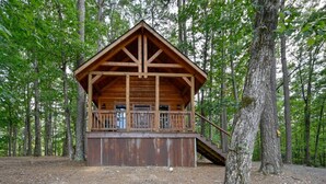 A wooden cabin with a balcony, surrounded by trees. - Cozy Cabin 3 miles to WPG Slps 4, ATV friendly (Mena)