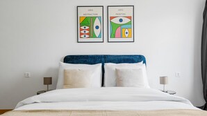 A hotel room with a bed, two bedside tables, and two framed artworks on the wall. - Blueground | Basel-Iselin, balcony, nr Rhine (Basel)
