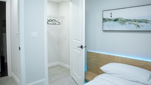 A bedroom with a bed, a door leading to a closet, and a framed picture on the wall. - Charming 2-bedroom house in delightful Calgary with WiFi (Calgary)