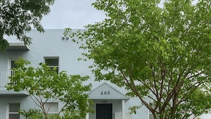 A two-story residential building with a black front door and the number 285 above it. - Wynwood Hostel (Miami)