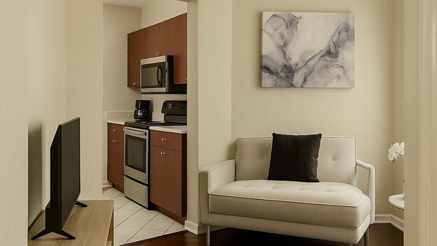 A modern living room with a sofa, a flat-screen TV, a wooden coffee table, and a kitchen in the background. - Wynwood Hostel (Miami)