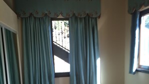 A room with a window, teal curtains, and a tiled floor. - Furnished bedroom, bathroom, kitchen in a guard-gated community (Bell Canyon)