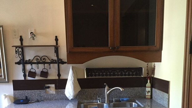 A kitchen with wooden cabinets, a granite countertop, a dishwasher, and a tiled floor. - Furnished bedroom, bathroom, kitchen in a guard-gated community (Bell Canyon)
