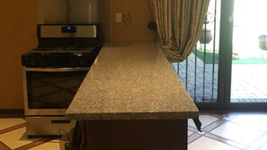 A kitchen with a stove, oven, and stainless steel range hood. - Furnished bedroom, bathroom, kitchen in a guard-gated community (Bell Canyon)